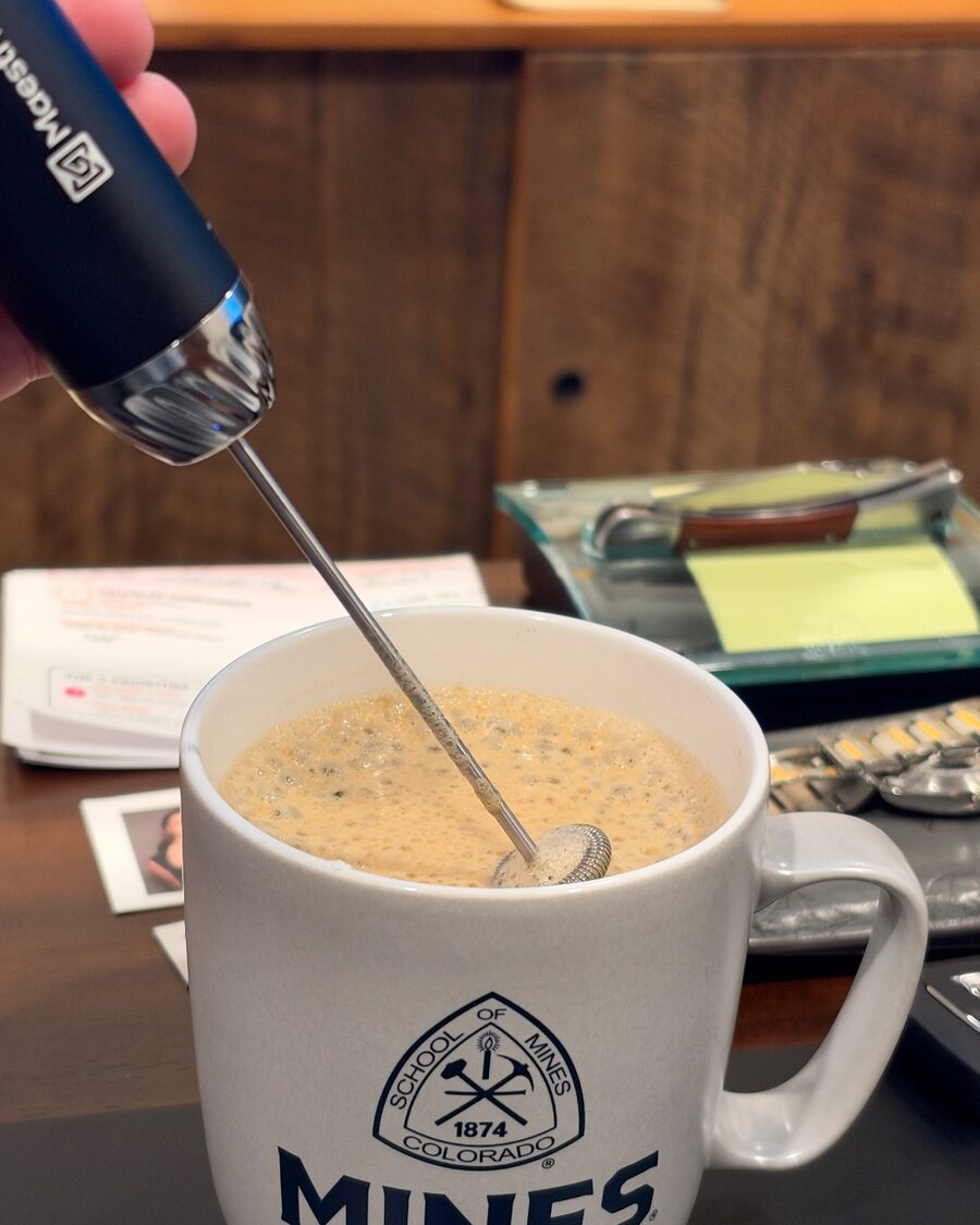 The LunaFro Max frothing a mug of coffee on our desk